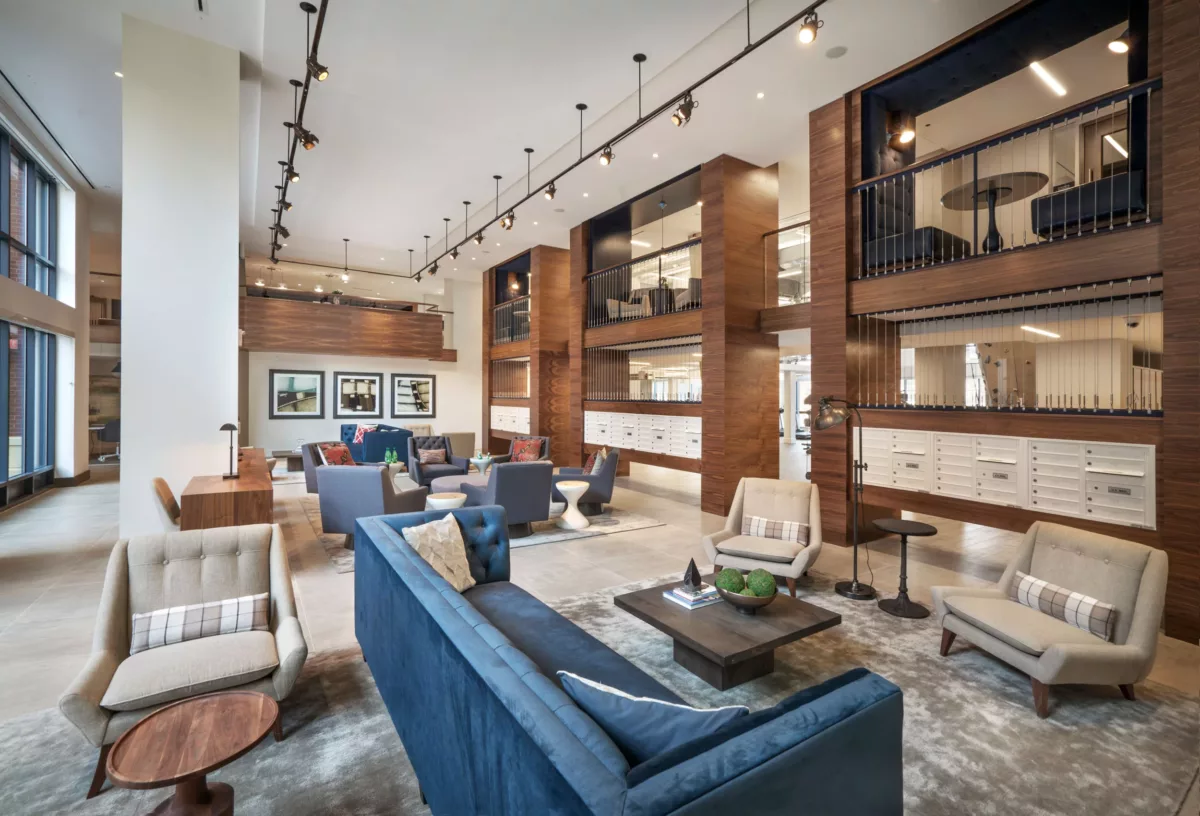 Coworking-style seating area with tables, chairs, and pendant lighting.