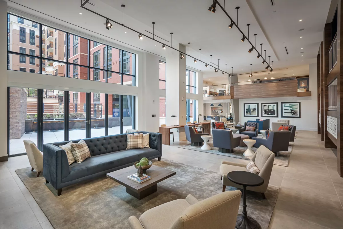 Modern living-style lounge with layered seating and large windows.