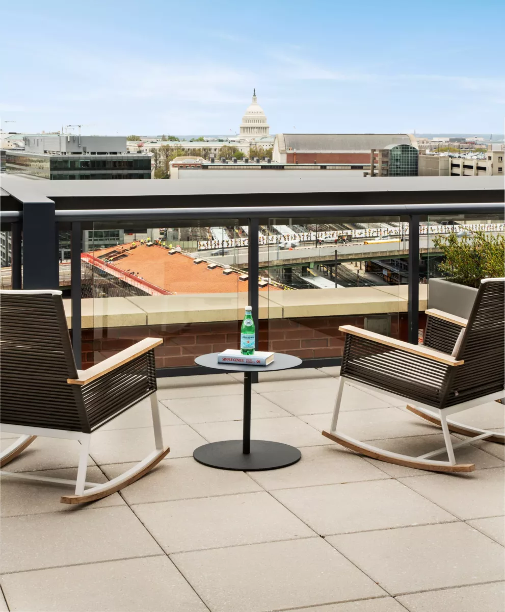 Rooftop terrace with outdoor seating, tables, and city skyline views.