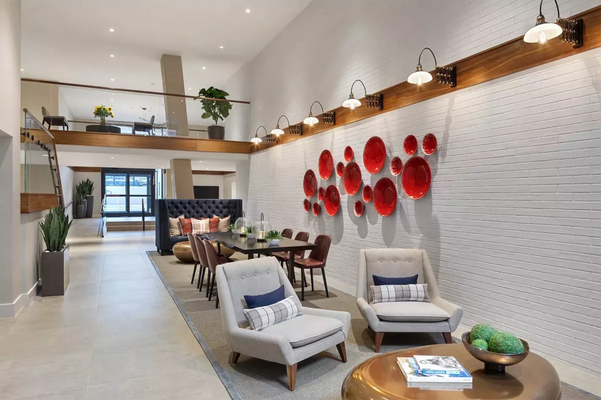 Lounge area with accent wall art, seating clusters, and warm lighting.
