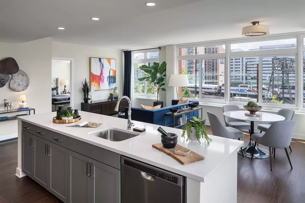 Modern kitchen with white cabinetry, stainless appliances, and island seating.