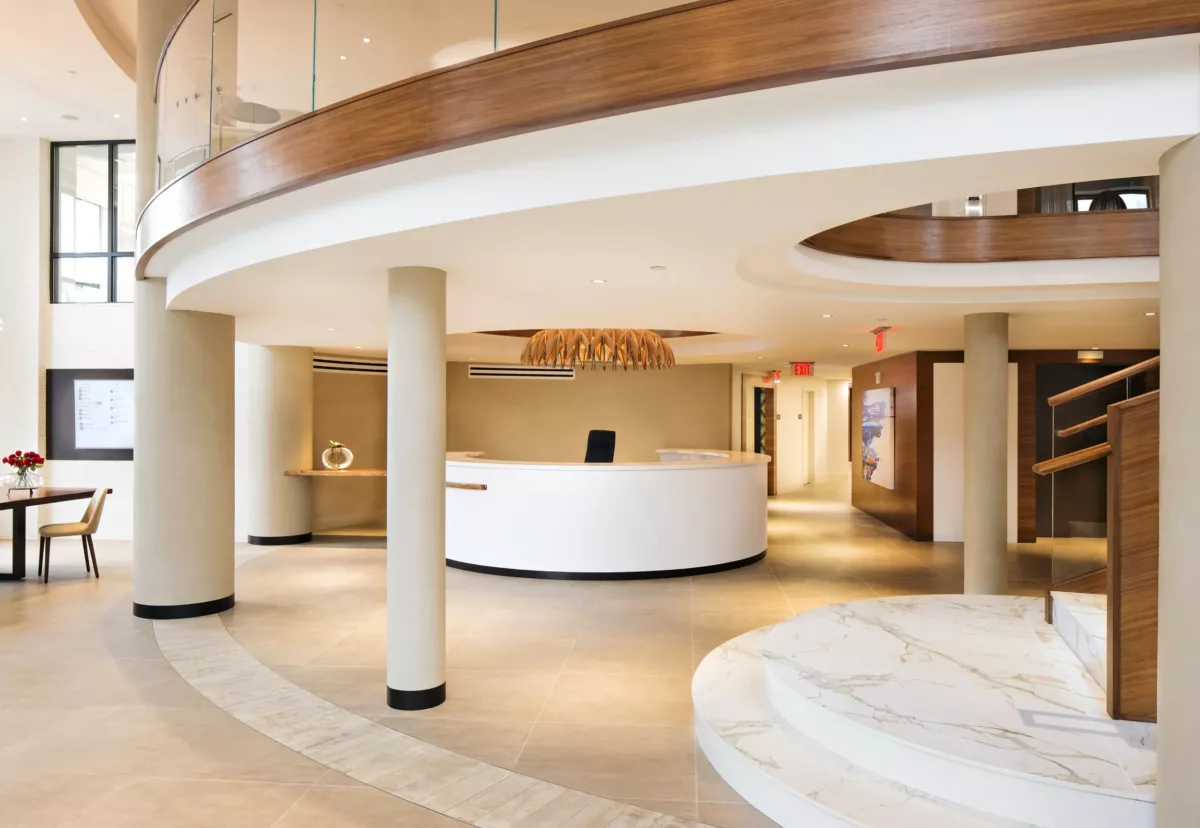 Bright reception area with curved architecture and warm wood detailing.