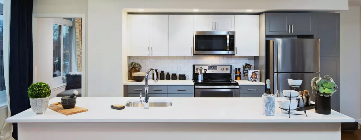 Kitchen with stainless steel range, microwave, and clean white cabinetry.