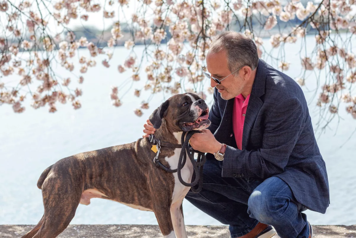 Man leaning down to hold dog