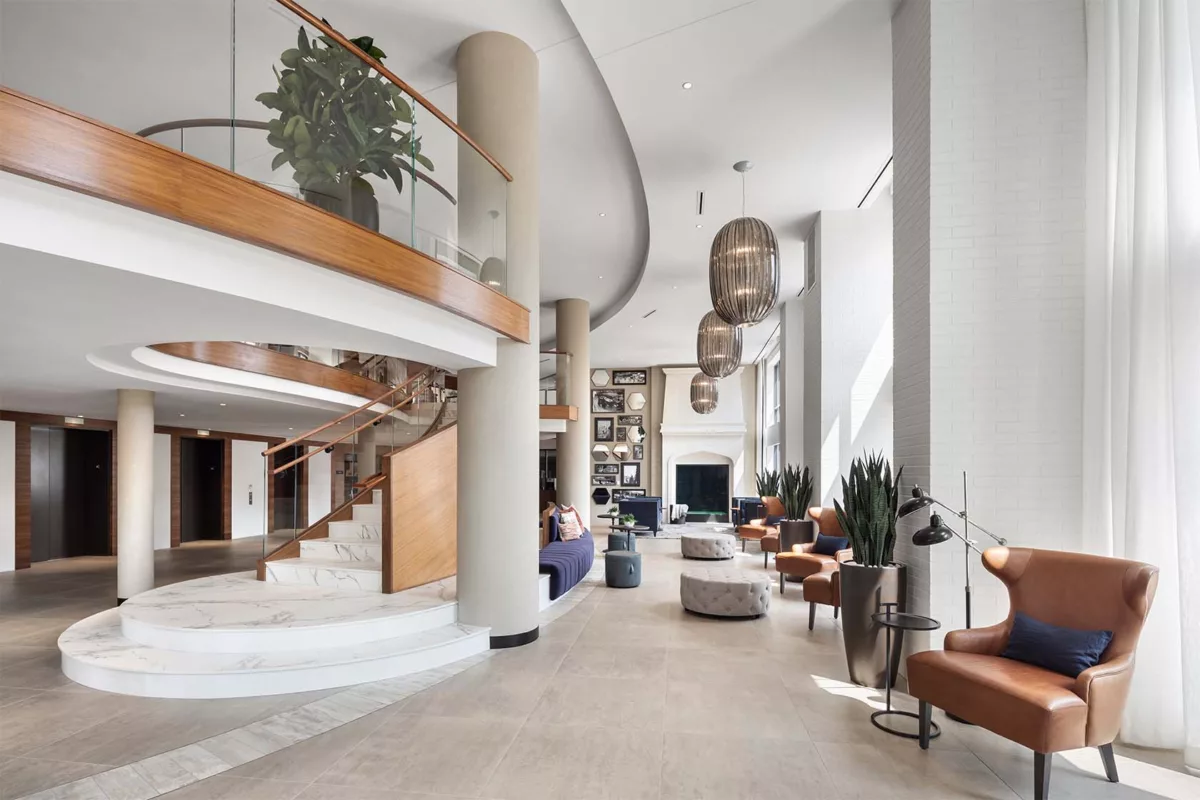 Union Place's light-filled two-story lobby featuring a fireplace and ample seating.